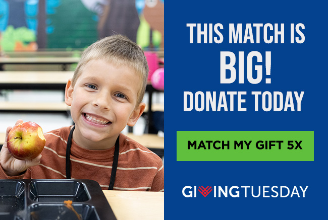 A boy sitting at a cafeteria table, holding up an apple with a bite out of it and smiling. A headline reads: This match is big! Donate today. A button reads: Match my gift 5 times. Below is the Giving Tuesday logo.