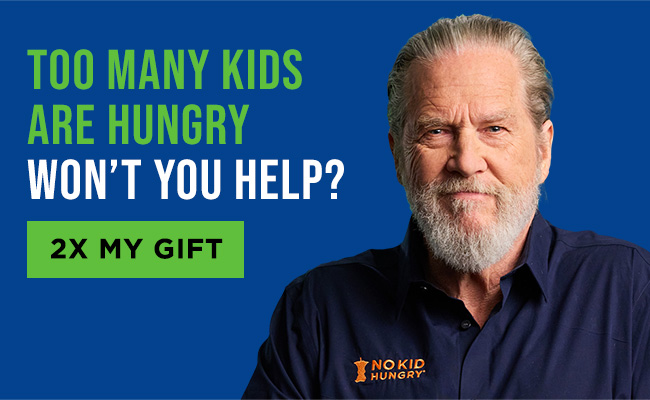Jeff Bridges wearing a No Kid Hungry shirt with a headline reading: Too many kids are hungry. Won’t you help? A button reads: 2X my gift
