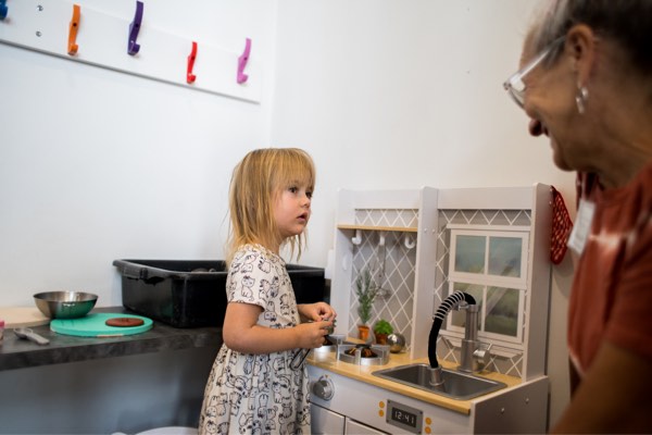 A girl playing at a toy kitchen